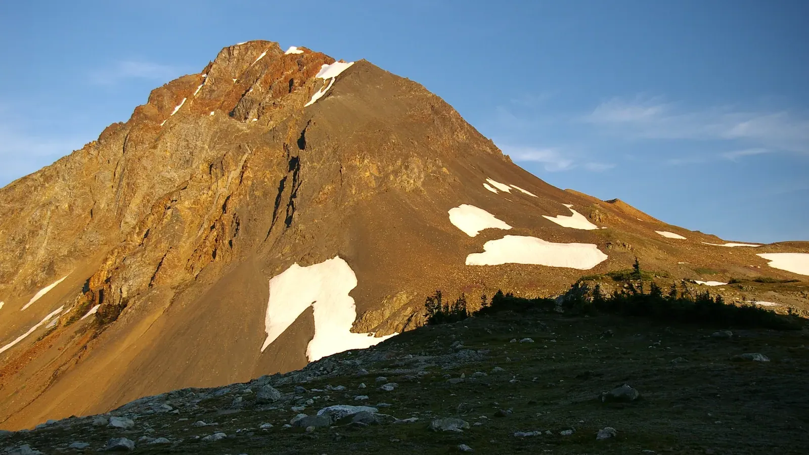 The rust colored face of Fissile Peak rising above Russet Lake in Garibaldi Provincial Park, British Columbia.