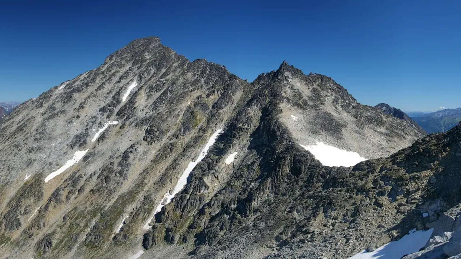 Mount Marriott in the Coast Mountains of British Columbia, a rocky summit with snow patches under a clear sky.